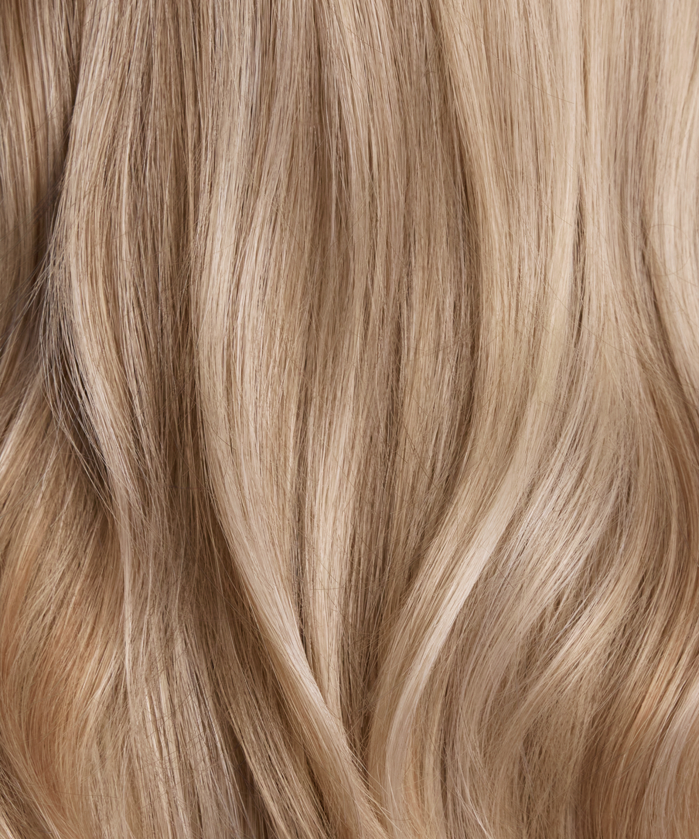 Creamy champagne blonde synthetic hair color and loose wave texture close-up