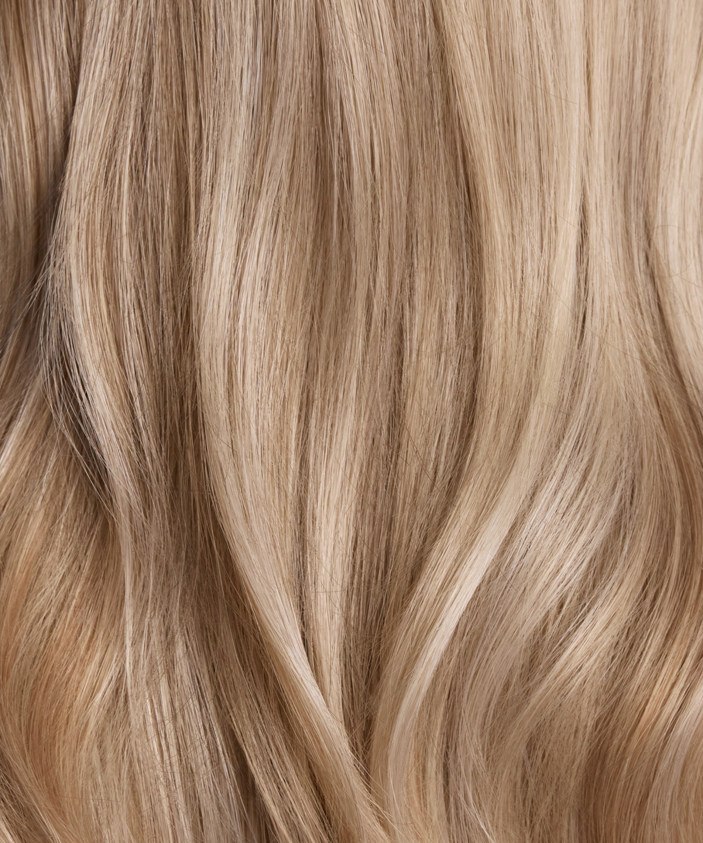 Creamy champagne blonde synthetic hair color and loose wave texture close-up