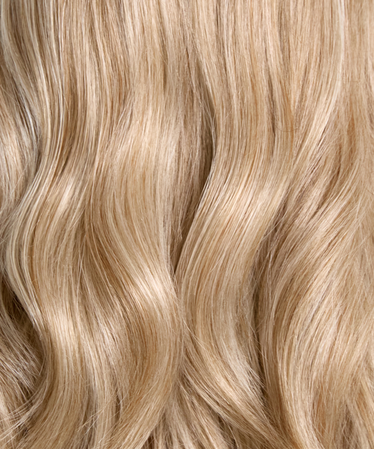 Dimensional blonde synthetic hair color and loose wave texture close-up